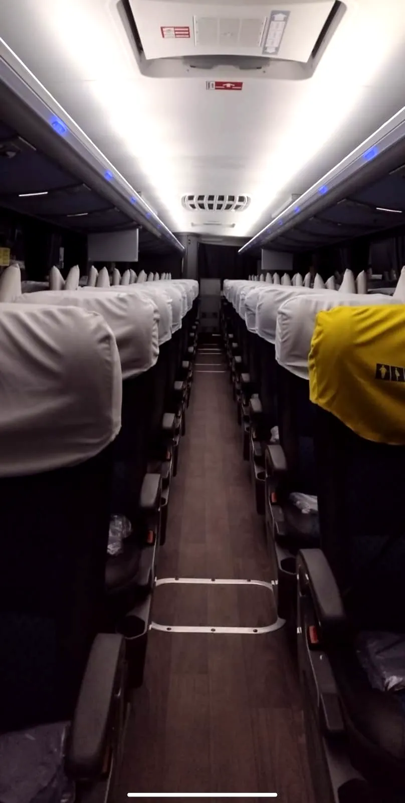 Corredor do ônibus semi-leito com as poltronas reclináveis arrumadas
