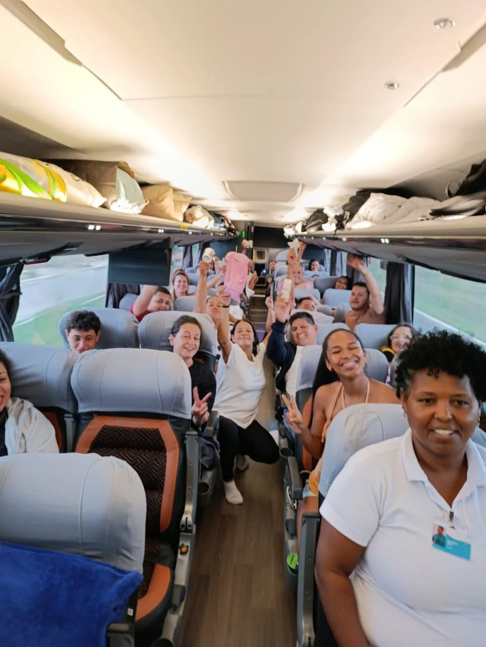 Passageiros sorrindo dentro do ônibus da excursão