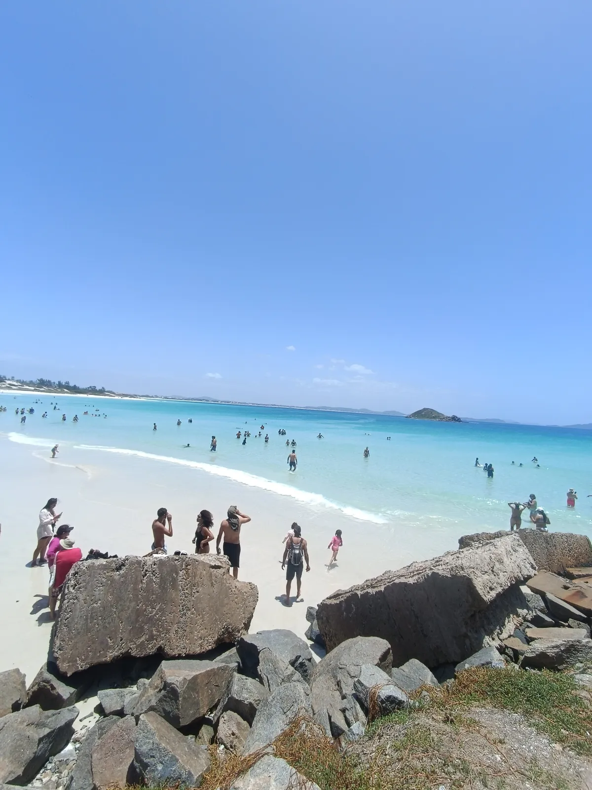Vista do alto das pedras sobre a praia cheia de Arraial do Cabo