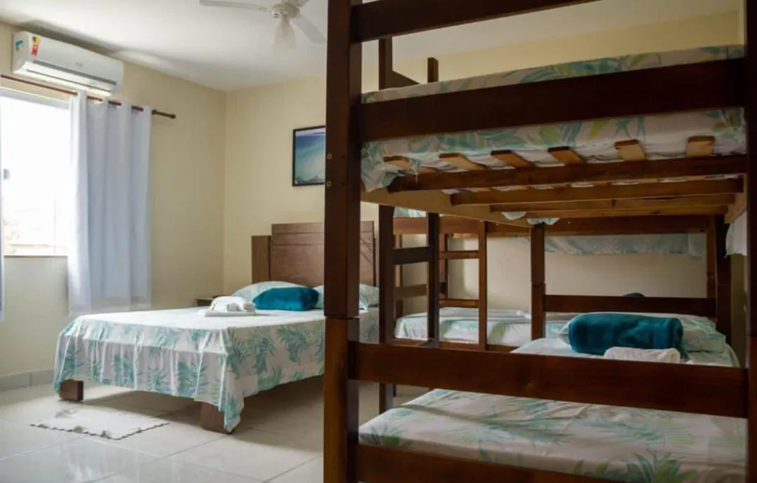 Outro ângulo do quarto da pousada, com beliche em primeiro plano